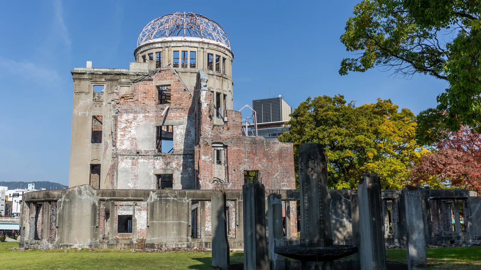 The Atomic Bomb Dome in Hiroshima Peace Memorial Park on a clear day, seen from the park side.