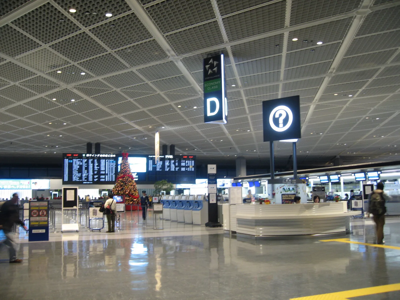 The departure hall of Narita Airport Terminal 1, South Wing, with check-in counters and an information desk. Photo from 2006.