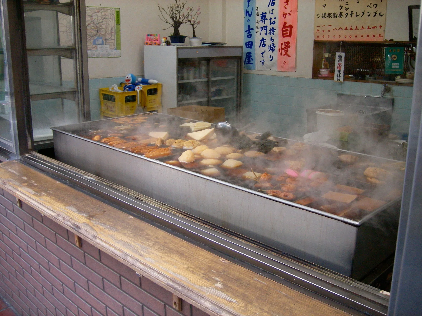 A large steel tray of oden (Japanese simmered hot-pot ingredients) steaming at a shop on the Sunamachi Ginza shopping street.