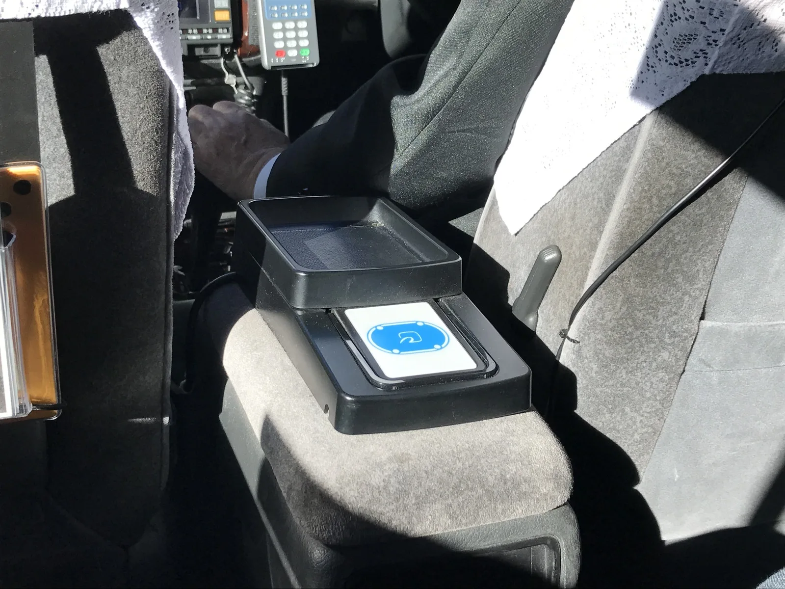 An IC card payment reader mounted inside a Japanese taxi, between the front seats.