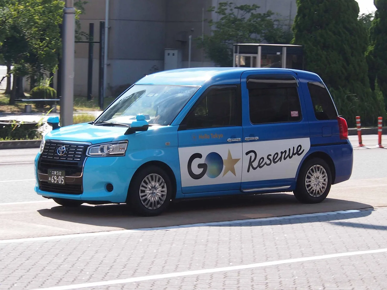 A blue Toyota JPN Taxi operated by Nihon Kotsu for the GO app's reserve service.